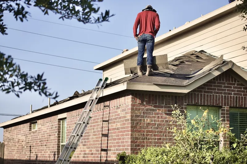 Professional roofer working on a residential roof in West Glen